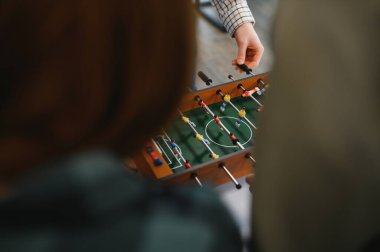 Ofis çalışanları arasında dostça bir masa futbolu oyunu oynuyorlar, arkadaşlığı teşvik ediyorlar ve stres atıyorlar.