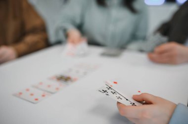 Arkadaşlar bir masanın etrafında toplanır, kağıt oynarlar ve eğlenirler, birlikte boş zamanlarının tadını çıkarırlar.