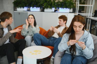 Genç yetişkinler oyun oynarken eğleniyor. Ben kimi oynuyorum? Alnına notlar yapıştırıp, kim olduğunu tahmin ediyorlar.