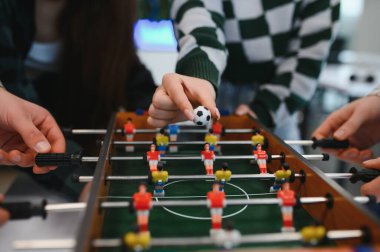 İş arkadaşları ara verip masa futbolu oynuyor, ofiste dostça bir rekabet içinde eğleniyor ve kaynaşıyorlar.