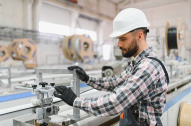 Modern endüstriyel bir fabrikada pvc pencere ve kapılar üreten odaklı fabrika işçisi işletim makinesi