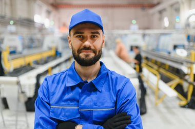 Alüminyum ve pvc 'den yapılmış pencere ve kapılar için modern bir üretim hattında dururken kendine güveni tam bir fabrika işçisi kollarını kavuşturuyor