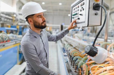 Modern bir fabrikada pvc, alüminyum pencere ve kapılar üreten sabit kasklı çalışma makineleri takan endüstri mühendisi