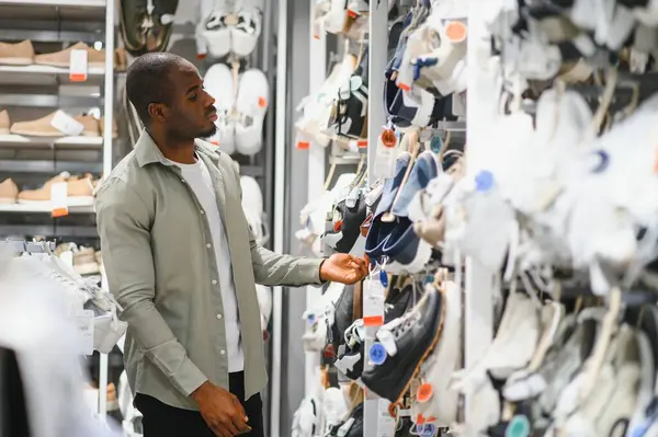 Müşteri bir mağazada yeni ayakkabılar arıyor, ayakkabı alışverişi yapıyor ve satın alma kararları veriyor.