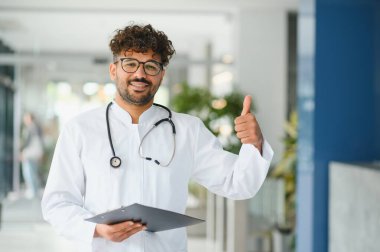 Hasta dosyasını tutan ve steteskop takan kendine güvenen bir pratisyen.