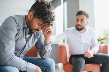 Terapi seansı sırasında üzgün hastayı teselli eden psikolog, akıl sağlığı sorunlarını tartışıyor ve destek sağlıyor.