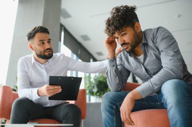 Terapi seansında acı çeken hastayı destekleyen psikolog, travma sonrası stres bozukluğuyla başa çıkmasına ve psikolojik destek sağlamasına yardımcı oluyor.