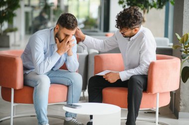 Terapi seansında sıkıntılı bir hastayı destekleyen psikolog empati ve rehberlik öneriyor.