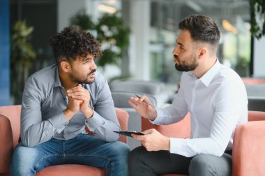 Üzgün Arap adam travma sonrası stres bozukluğu için terapi seansında psikologdan psikolojik destek alıyor.