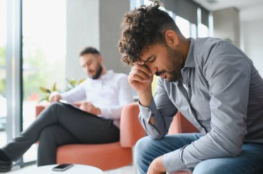 Travma sonrası stres bozukluğundan muzdarip Arap bir psikologla terapi seansı yapıyor not alıyor, psikolojik destek kavramı...