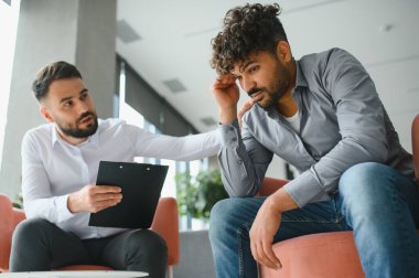 Terapi sırasında üzgün Arap hastayı destekleyen psikolog, travma sonrası stres bozukluğuna değiniyor ve zihinsel sağlık hizmetleri sunuyor.