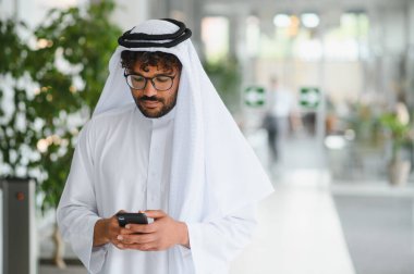 Modern ofis alanında cep telefonu kullanan başarılı girişimci, gelenek ve teknoloji arasındaki bağlantıyı gösteriyor