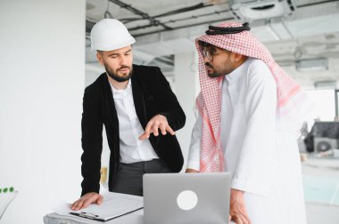 İnşaat çalışmalarının yapıldığı toplantıda Arap yatırımcılara dizüstü bilgisayardaki inşaat planını açıklayan mimar