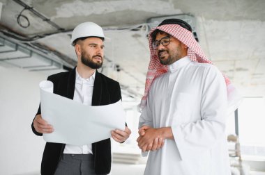 Mimar, inşaat halindeki yatırımcıyla planlar taşıyordu ve tartışıyordu.