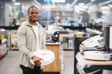 Mutlu müşteri alışveriş merkezindeki elektronik mağazasından yeni bir robot elektrikli süpürge alıyor.