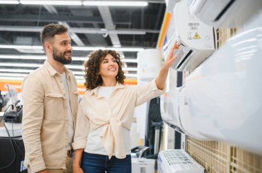 Mutlu çift yeni bir klima seçiyor ve evleri için satın alma kararları veriyor.