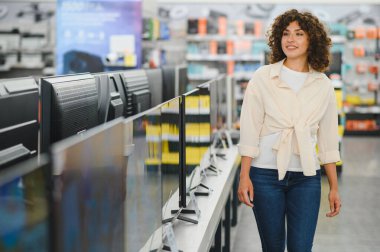 Müşteri, en iyi cihazları arayarak, tüketici elektroniği mağazasında TV 'ler boyunca yürüyor