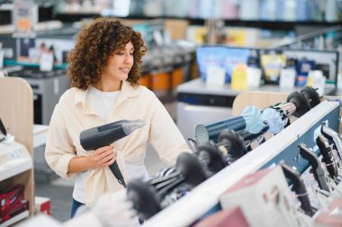 Müşteri saç kurutma makinelerini karşılaştırıyor, perakende mağazasından ev aletleri alıyor, satın alma kararı veriyor.