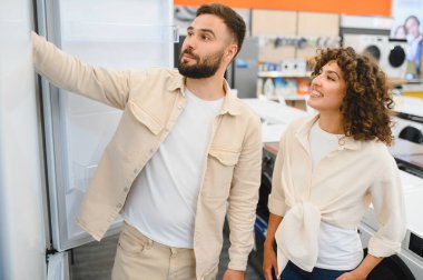 Mutlu çift elektronik mağazasından yeni buzdolabı seçiyor, ev aletleri, alışveriş ve tüketim konseptini inceliyor