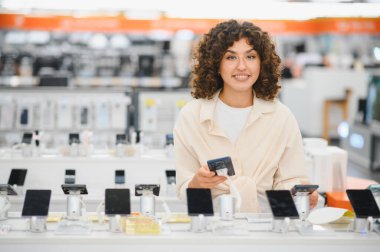 Müşteri, perakende mağazası ortamında en son teknolojiyi satın alırken çeşitli yeni cep telefonlarını karşılaştırıyor