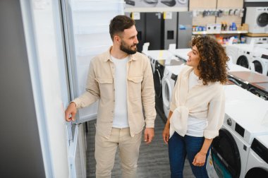 Mutlu çift yeni bir buzdolabı seçiyor, alışveriş sürecinin tadını çıkarıyor ve tercihlerini birlikte tartışıyorlar.