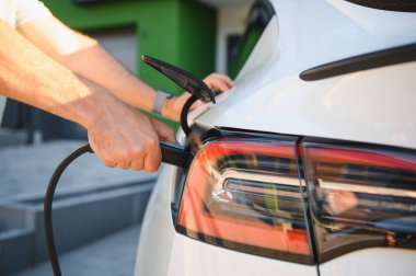 Konut alanındaki elektrikli arabaları şarj eden adama yakın çekim