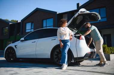 Çift, yenilenebilir yeşil enerji, sürdürülebilir ulaşım ve çevre dostu yaşam tarzını kullanarak modern evlerinde elektrikli araçlarını şarj ediyor.