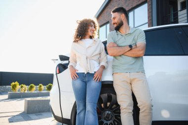 Genç ev sahipleri elektrikli araçlarını şarj etmenin keyfini çıkararak, ekolojik bilinçli yaşama ve yenilenebilir enerjiye bağlılıklarını sergiliyorlar.