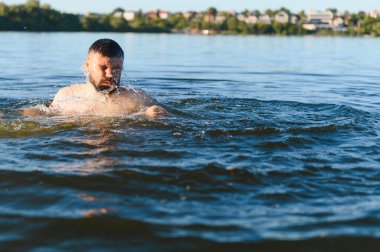 Sakallı adam kıyıya yakın derin mavi sularda boğuluyor, yaz tatilinde kaza konsepti.
