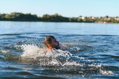 Yaz tatili boyunca gölde boğulan sakallı bir adam ayakta kalmak ve nefes almak için çırpınıyor.
