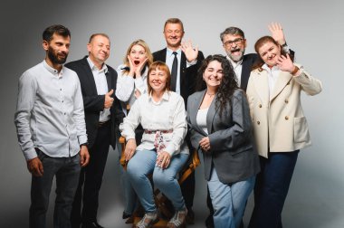 Neşe ve takım çalışmasını ifade eden çeşitli profesyonel gruplar, bir iş toplantısında elde edilen başarıları kutluyor, liderlik ve işbirliği sergiliyor.