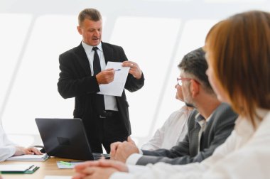 Üst düzey bir yönetici olarak dikkatle dinleyen işletme ekibi, ortaklaşa bir ofis toplantısında stratejiyi, takım çalışmasını ve büyümeyi teşvik ederek açıklıyor.