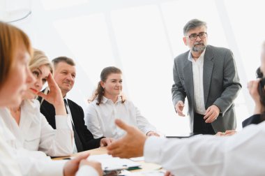 Parlak, modern bir ofiste üst düzey yöneticileriyle görüşen iş adamları, işbirliği ve stratejik planlamayı teşvik ediyorlar.