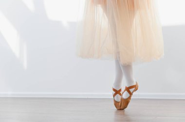 Genç balerin bale hareketleri yapıyor, dans stüdyosunda parmak uçlarında duruyor, bale ayakkabısı ve bale ayakkabısı giyiyor, zarafet ve adanmışlık sergiliyor.