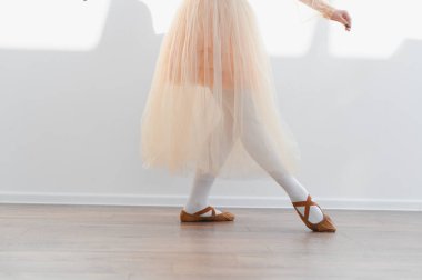 Genç balerin bir dans stüdyosunda bale çalışıyor, etek ve bale ayakkabıları giyiyor, zarafet ve kendini dans sanatına adamış.