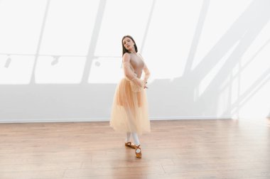 Genç balerin, parlak bir stüdyoda bale çalışıyor. Hareketlerinde zarafet ve duruş sergiliyor.