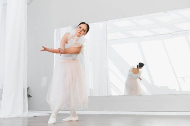 Yaşlı balerin zarif bir şekilde dans eder. Parlak bir stüdyoda. Tutkusunu ve kendini baleye adadığını gösterir.