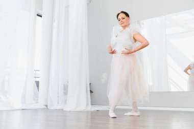 Parlak bir stüdyoda bale yapan yaşlı bir kadın zarif hareketlerinde zarafet ve dans tutkusu sergiliyor.