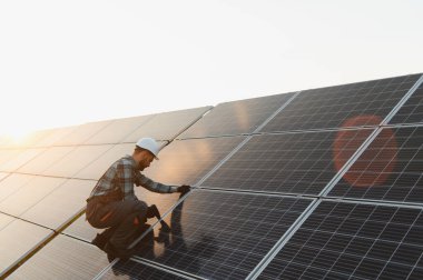 Teknisyen fotovoltaik paneller kuruyor, güneşten temiz ve sürdürülebilir elektrik üretiyor. Yeşil enerji çözümlerinin tanıtımı