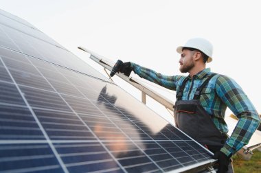 Erkek teknisyen güneş paneli kuruyor, yeşil bir gelecek için yenilenebilir ve sürdürülebilir enerji üretimi üzerinde çalışıyor