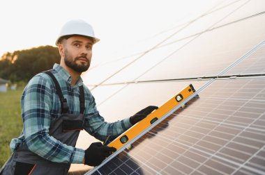 İşçi güneş panelleri kuruyor, verimli yenilenebilir enerji üretimi için mükemmel bir hizalama sağlıyor