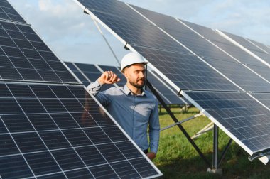 Yenilenebilir enerji çiftliğinde güneş enerjisi üretimini denetleyen mühendis, sürdürülebilir elektrik üretimini garanti altına alıyor.