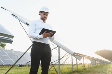 Güneş paneli performansını değerlendiren mühendis, bir güneş çiftliğinde verimli yenilenebilir enerji üretimi sağlıyor