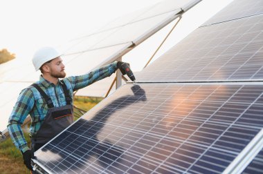 Güneş panelleri kuran mühendis sürdürülebilir yeşil enerjiye ve daha temiz bir çevreye katkıda bulunuyor. Sürdürülebilir geleceğe güç