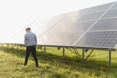 Mühendis, temiz enerji ve sürdürülebilirliği destekleyen geniş bir dizi güneş paneli üzerinde inceleme ve bakım yapıyor.