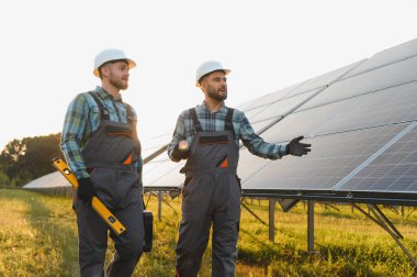 Güneş paneli kurulumunu tartışan iki mühendis sürdürülebilir yeşil enerji teknolojisiyle çalışıyorlar.