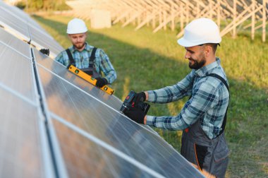Yeni güneş panelleri inşa eden mühendisler, sürdürülebilir enerji ve çevre dostu teknoloji üzerinde çalışıyorlar.
