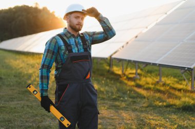 Mühendis fotovoltaik paneller kuruyor, sürdürülebilir bir gelecek için yenilenebilir enerji üretimine katkıda bulunuyor