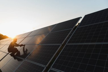 Technician inspecting and cleaning photovoltaic panels, ensuring renewable energy production for a sustainable future