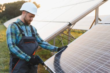 Güneş paneli kurmak için matkap kullanan teknisyen, yeşil enerji üretimine ve sürdürülebilir gelişime katkıda bulunuyor
